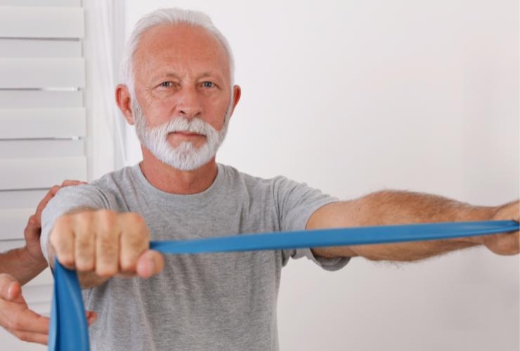 uomo che fa un esercizio con l'elastico in mano