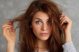 Donna che si tocca capelli crespi