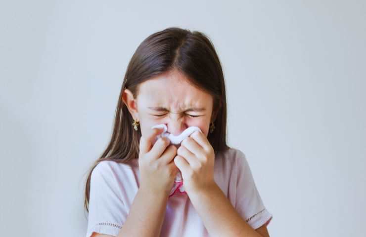 bambina si soffia il naso