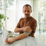 uomo che si misura la pressione