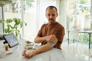 uomo che si misura la pressione