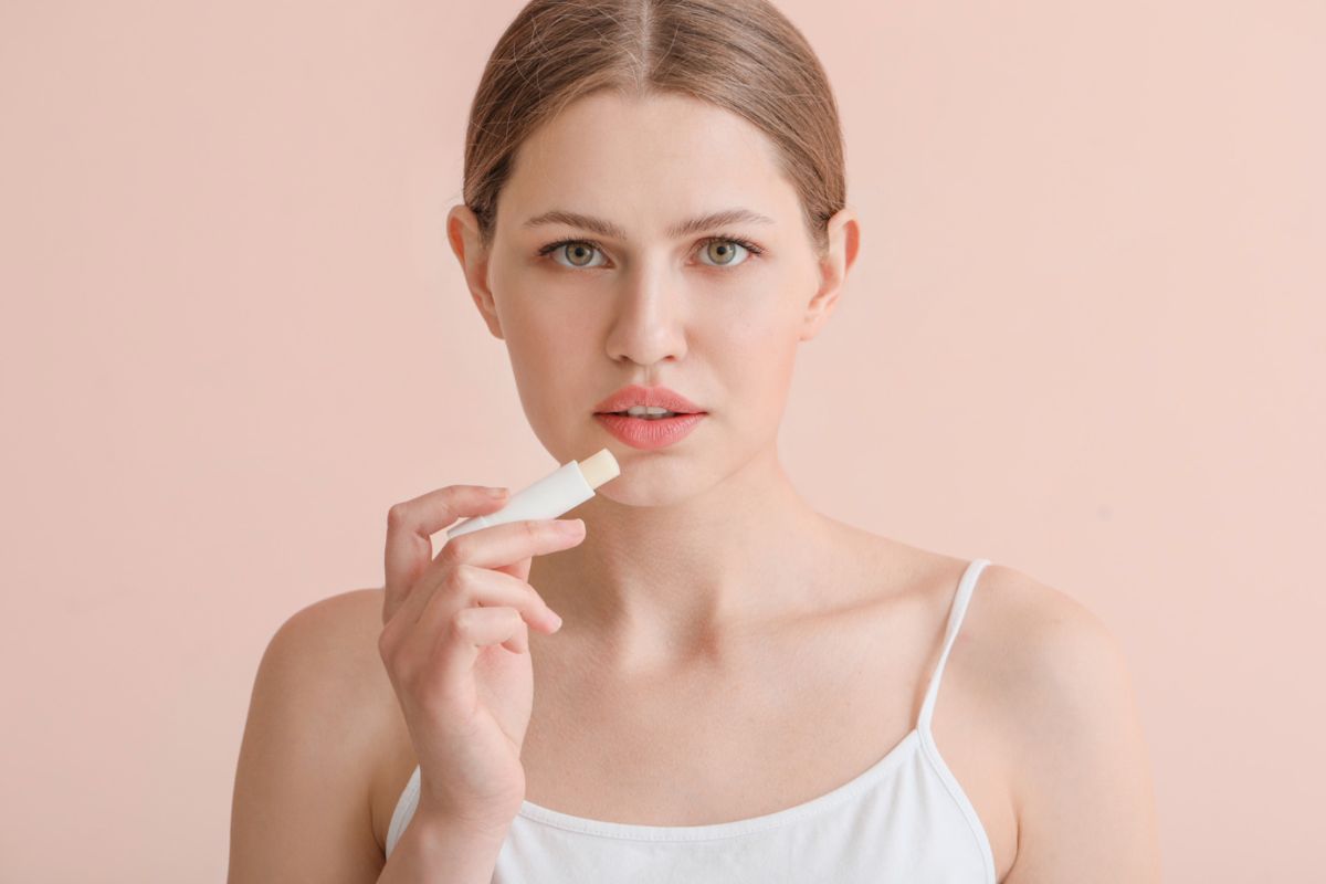 Donna che mette burrocacao sulle labbra