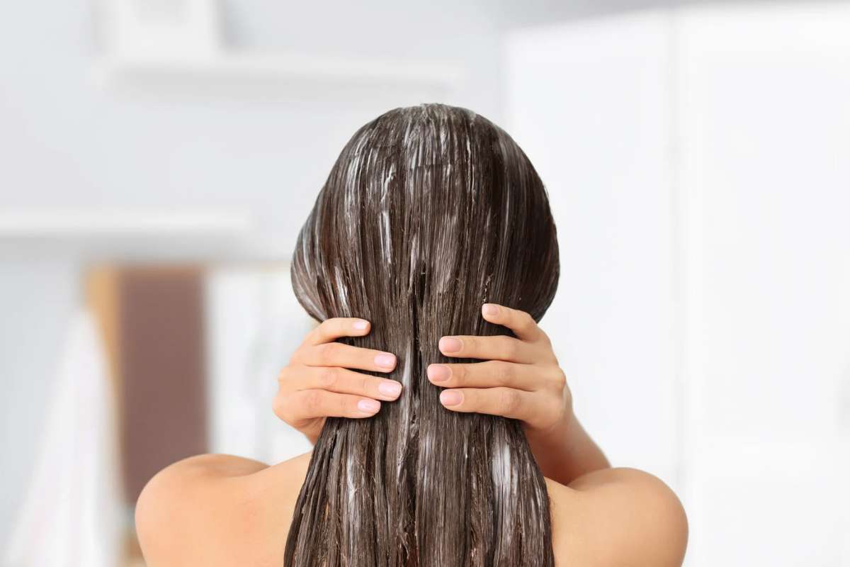 Donna che applica maschera sui capelli