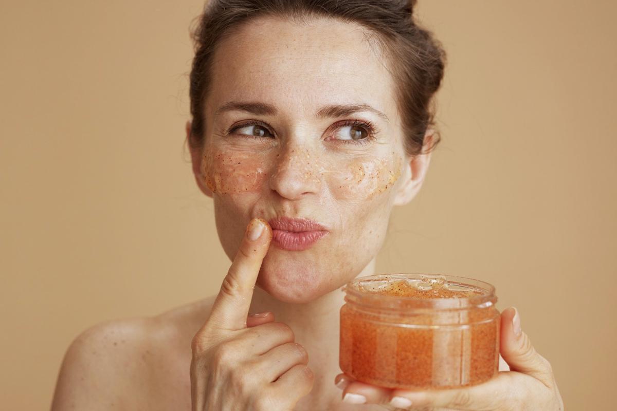 Donna con barattolo scrub in mano