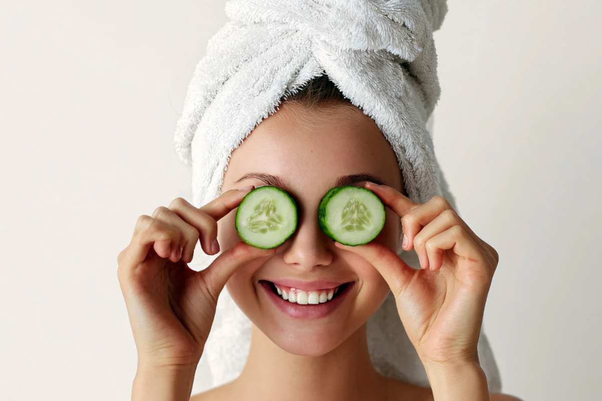 Donna con fettine di cetriolo sugli occhi